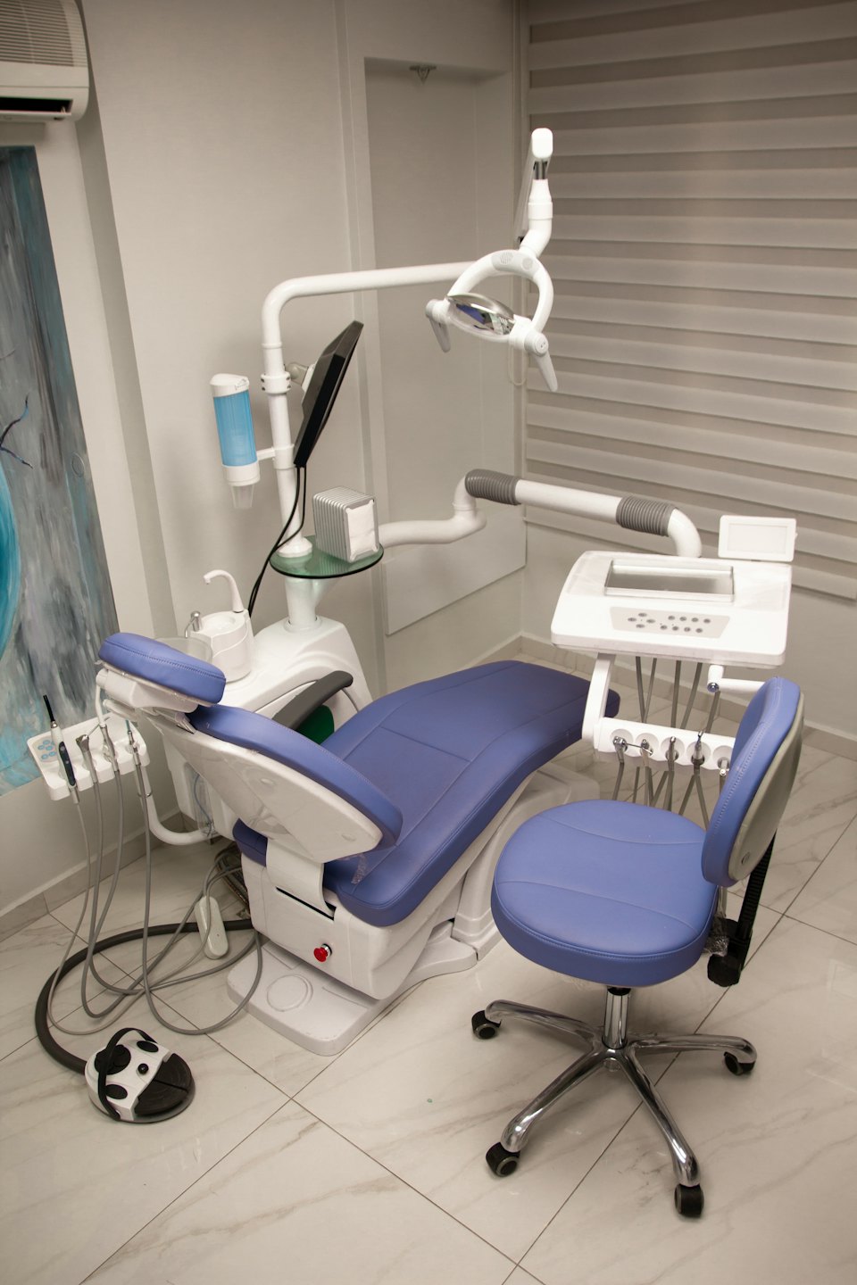 Consultorio dental moderno con silla azul y blanca.